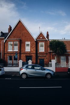 Scenic view of red brick houses with a car parked on a street.